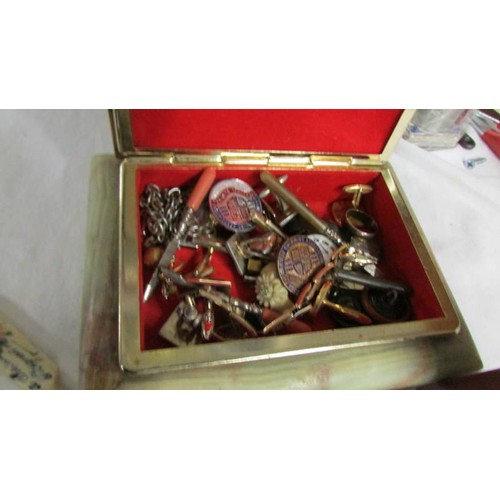 1135 - An Onyx jewellery box with cuff links, badges, medallions etc.,