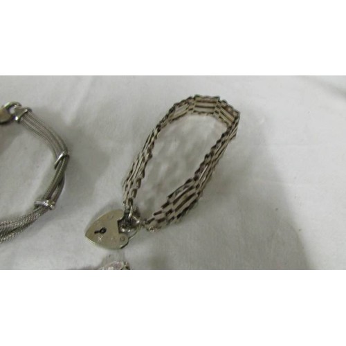 1140 - A silver gate bracelet and two other silver bracelets.