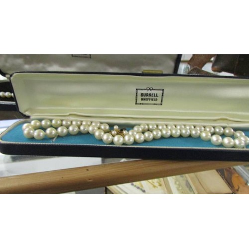 1219 - A small vintage vanity case containing various pearls with gold and silver clasps and assorted old j... 