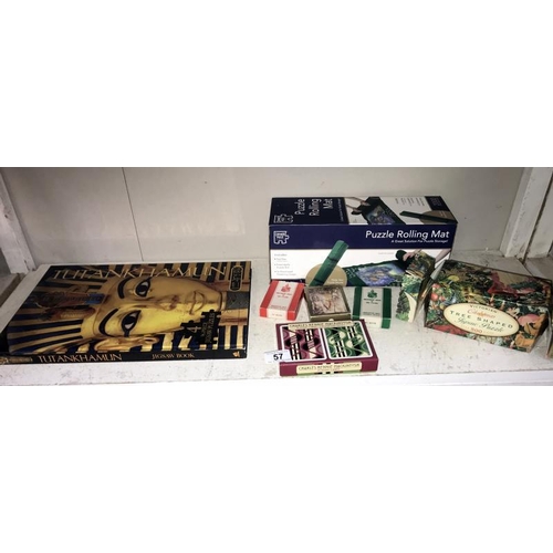 57 - A Tutankhamun 4 x 96 piece jigsaw as a book, jigsaw rolling mat, playing cards and 1 other jigsaw