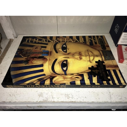 57 - A Tutankhamun 4 x 96 piece jigsaw as a book, jigsaw rolling mat, playing cards and 1 other jigsaw