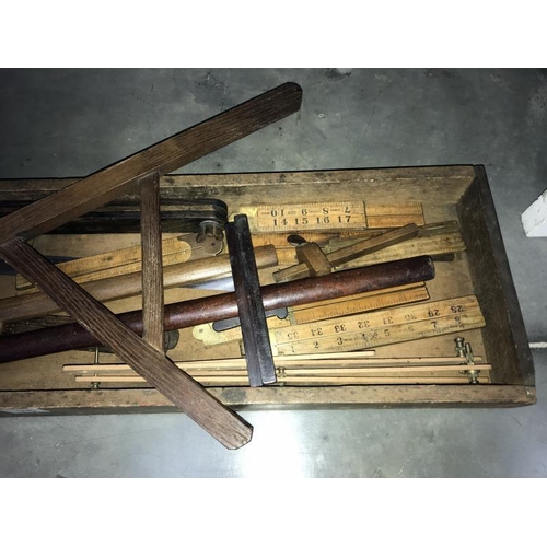 75 - An old wooden tray of vintage tools including rulers,  spirit level etc.