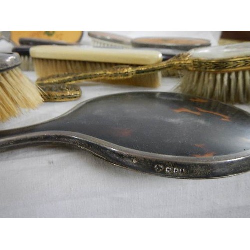 524 - A mixed lot of vintage hand mirrors and hair brushes including two with silver frames.