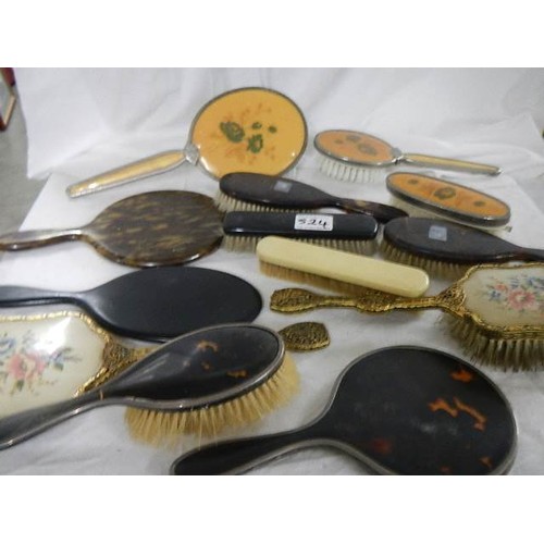 524 - A mixed lot of vintage hand mirrors and hair brushes including two with silver frames.