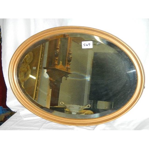 549 - An oval gilt framed bevel edged mirror.