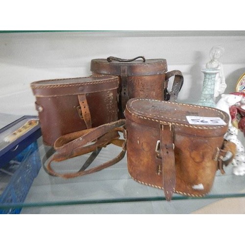 565 - Three old leather binocular cases.