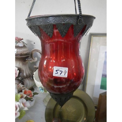 579 - A hanging red glass candle lamp.