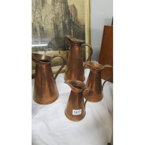 1417 - A set of four graduated copper jugs.