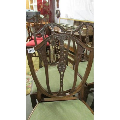 1545 - A set of four mahogany shield back dining chairs.