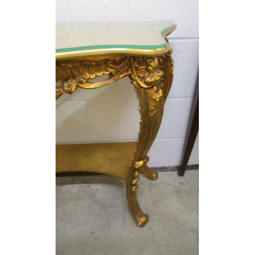 1606 - A gilded console table with glass top.