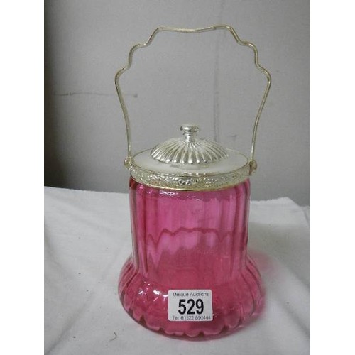 529 - A cranberry glass biscuit barrel with plated fittings.