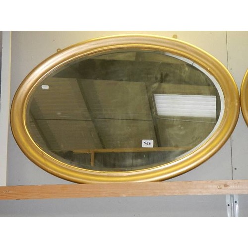 568 - An oval gilt framed bevel edged mirror.