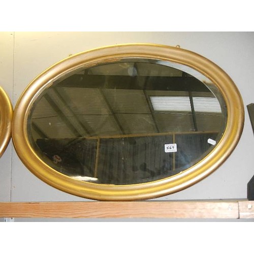 569 - An oval gilt framed bevel edged mirror.