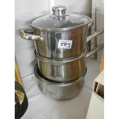 583 - A set of stainless steel pans.