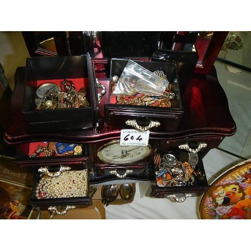 604 - A jewellery box with clock containing an assortment of costume jewellery.