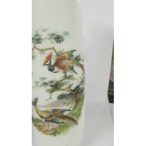 1202 - Two hand painted glass vases:- 1 blue with floral pattern and 1 opaque with birds.