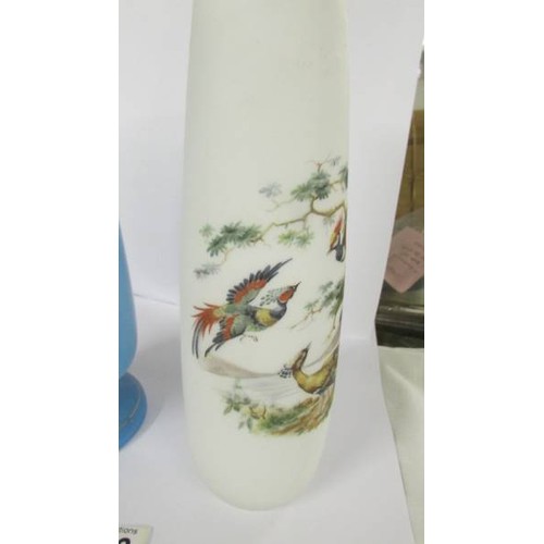 1202 - Two hand painted glass vases:- 1 blue with floral pattern and 1 opaque with birds.