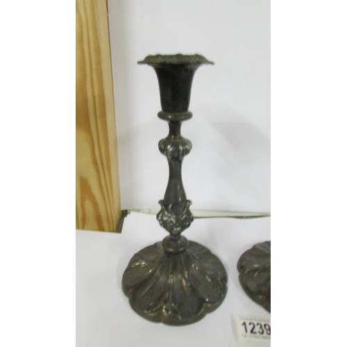 1239 - A pair of ornate silver plate candlesticks.