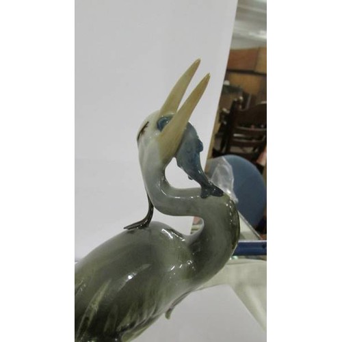 1242 - A Royal Dux figure of a heron with a fish in its mouth, in good condition.