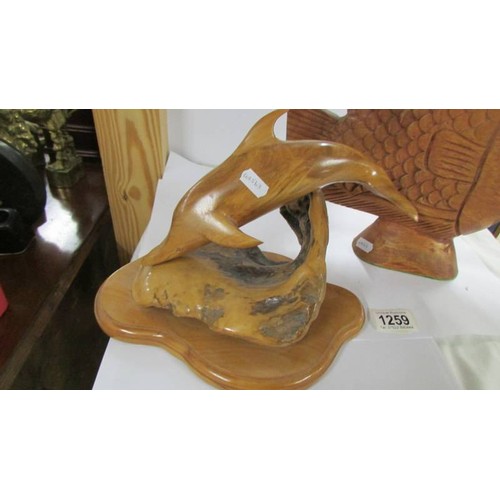 1259 - A carved wood dolphin and another carved fish.