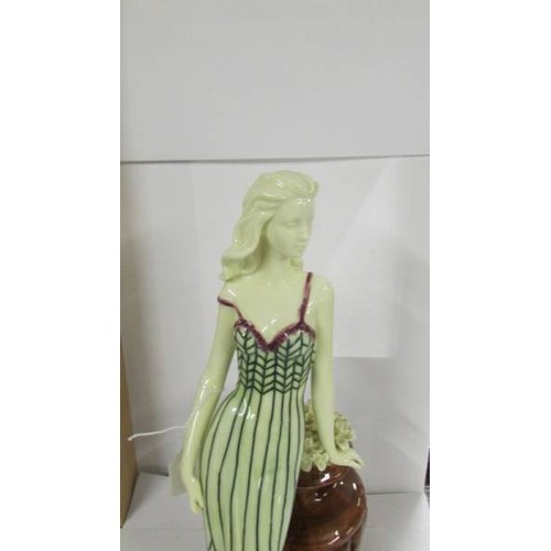 1265 - An Old Tupton ware figure of a woman leaning on an urn,