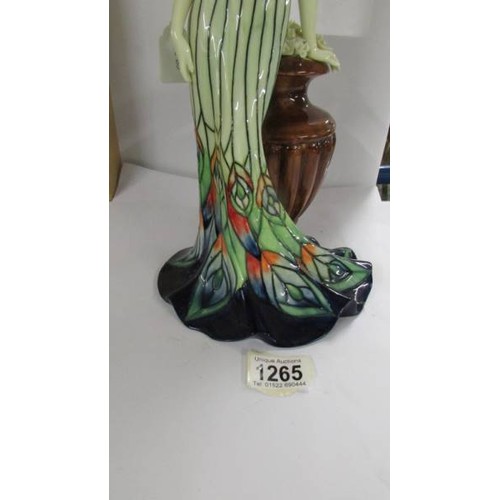 1265 - An Old Tupton ware figure of a woman leaning on an urn,