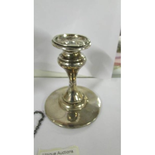 1277 - A silver candle holder, silver spill vase and silver sherry label.