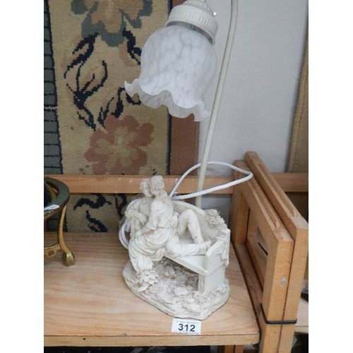 312 - A table lamp with lover's on bench base.