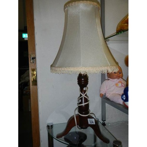 334 - A three legged oak table lamp.