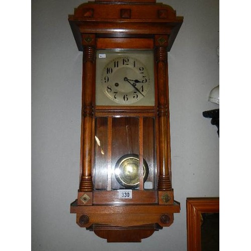 330 - An Edwardian oak cased spring wind wall clock, in working order.   COLLECT ONLY.