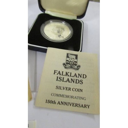 1149 - Two Cased Falkland Islands silver crowns, Liberation and 150th anniversary, with certificates.