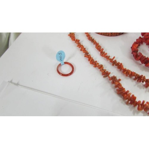 1078 - A red coral necklace, a pink coral necklace, two bangles and a similar ring.