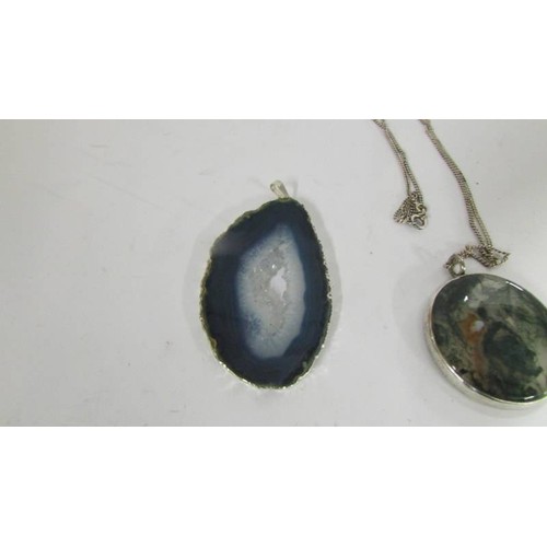 1080 - A moss agate pendant in silver with attached silver chain together with a pendant in silver mount.