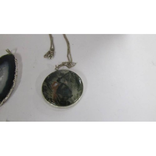 1080 - A moss agate pendant in silver with attached silver chain together with a pendant in silver mount.