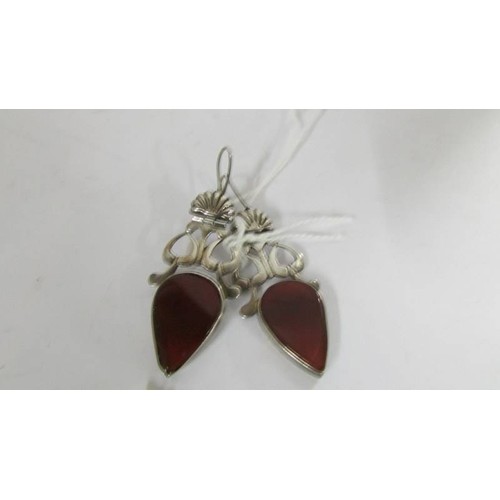 1087 - A pair of pendant earrings set with carnelian stone in silver.