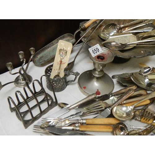 659 - A mixed lot of flat ware, toast rack, candlesticks etc.,