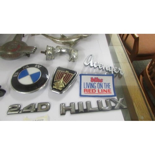 1381 - A mixed lot of car badges including Morris Minor bonnet mascot etc.,