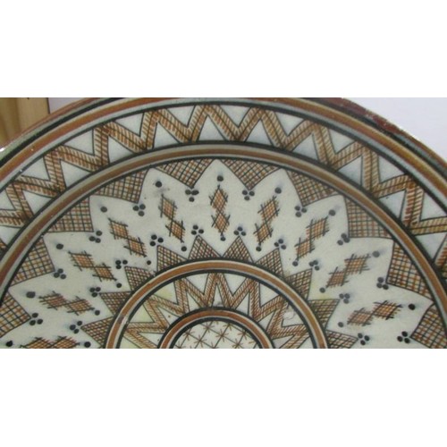 1423 - A large middle eastern ceramic dish, 42 cm diameter.