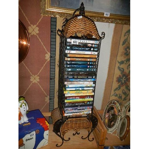 683 - A cane and metal DVD rack with DVD's, COLLECT ONLY.