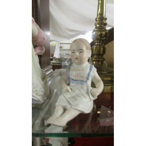 1487 - A bisque porcelain figure of a small girl seated and another figure 'Papa's Darling'.