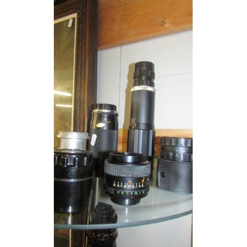 1551 - Two shelves of vintage camera lenses.