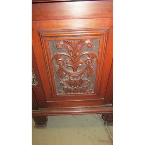 1583 - A mahogany cupboard with carved door and side panels, 95 x 56 x 56 cm.  COLLECT ONLY.