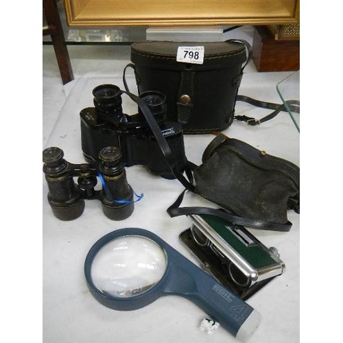 798 - Three binoculars and a magnifying glass.