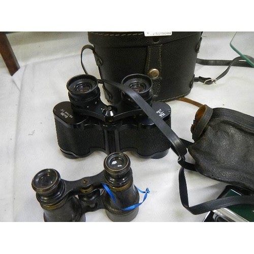 798 - Three binoculars and a magnifying glass.