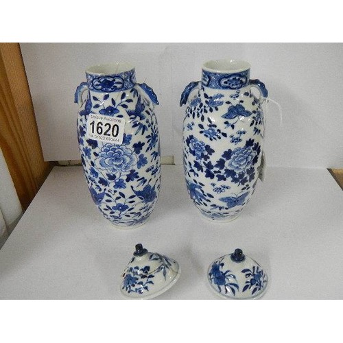 1620 - A pair of Chinese blue and white lidded vases (both lids a/f).