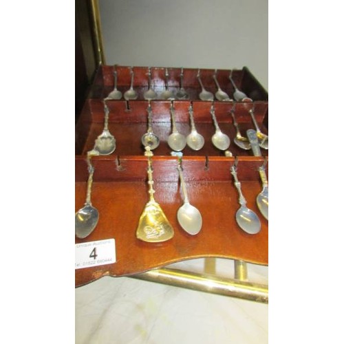 4 - Twenty souvenir spoons on a wall rack.