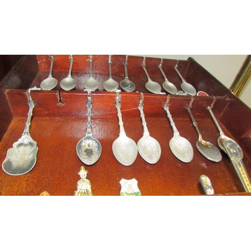 4 - Twenty souvenir spoons on a wall rack.