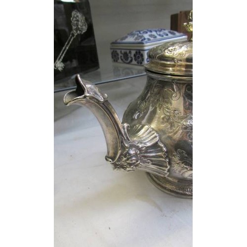 10 - An ornate silver plate teapot, lid needs fixing otherwise in good condition.