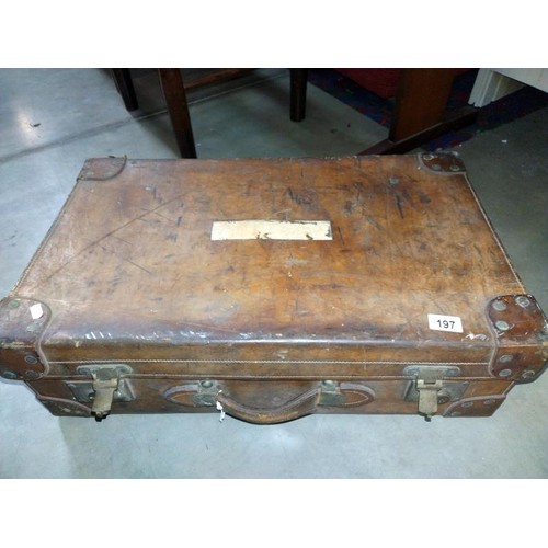 197 - A large early leather suitcase (missing brass plaque on lid)