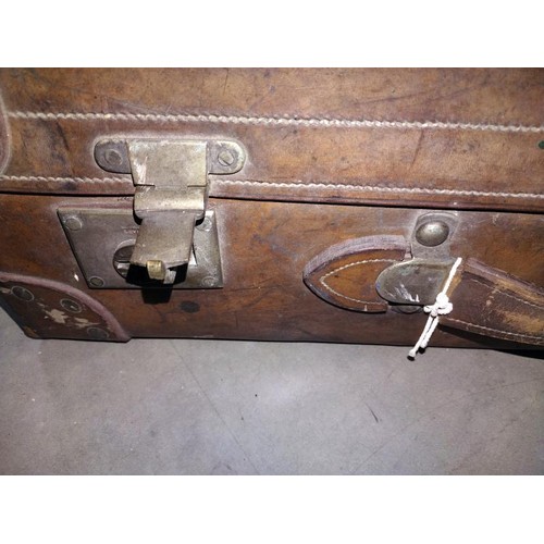 197 - A large early leather suitcase (missing brass plaque on lid)